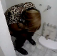 A black girl takes a shit in a ghetto house bathroom. There is no toilet paper, and the roll dispenser is broken. No pooping sounds that we could hear. Maybe you can hear it?